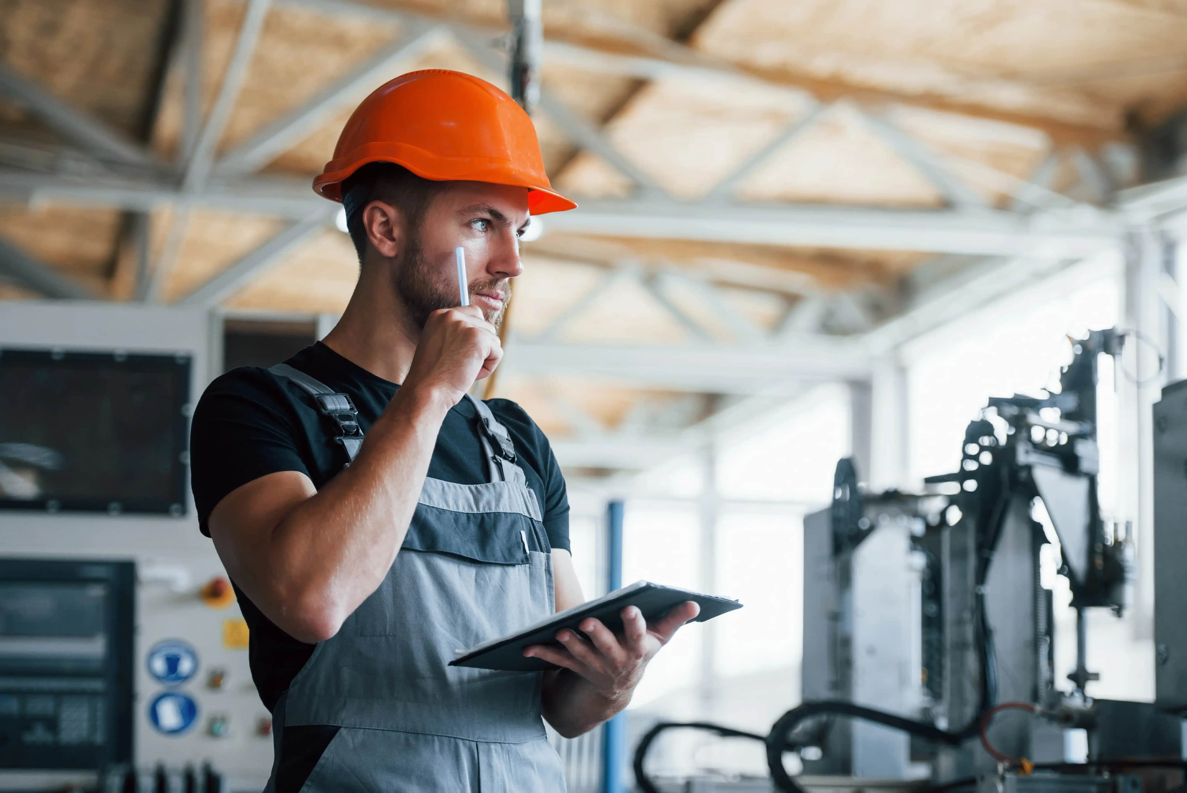 Builder in orange hard hat holding a notepad