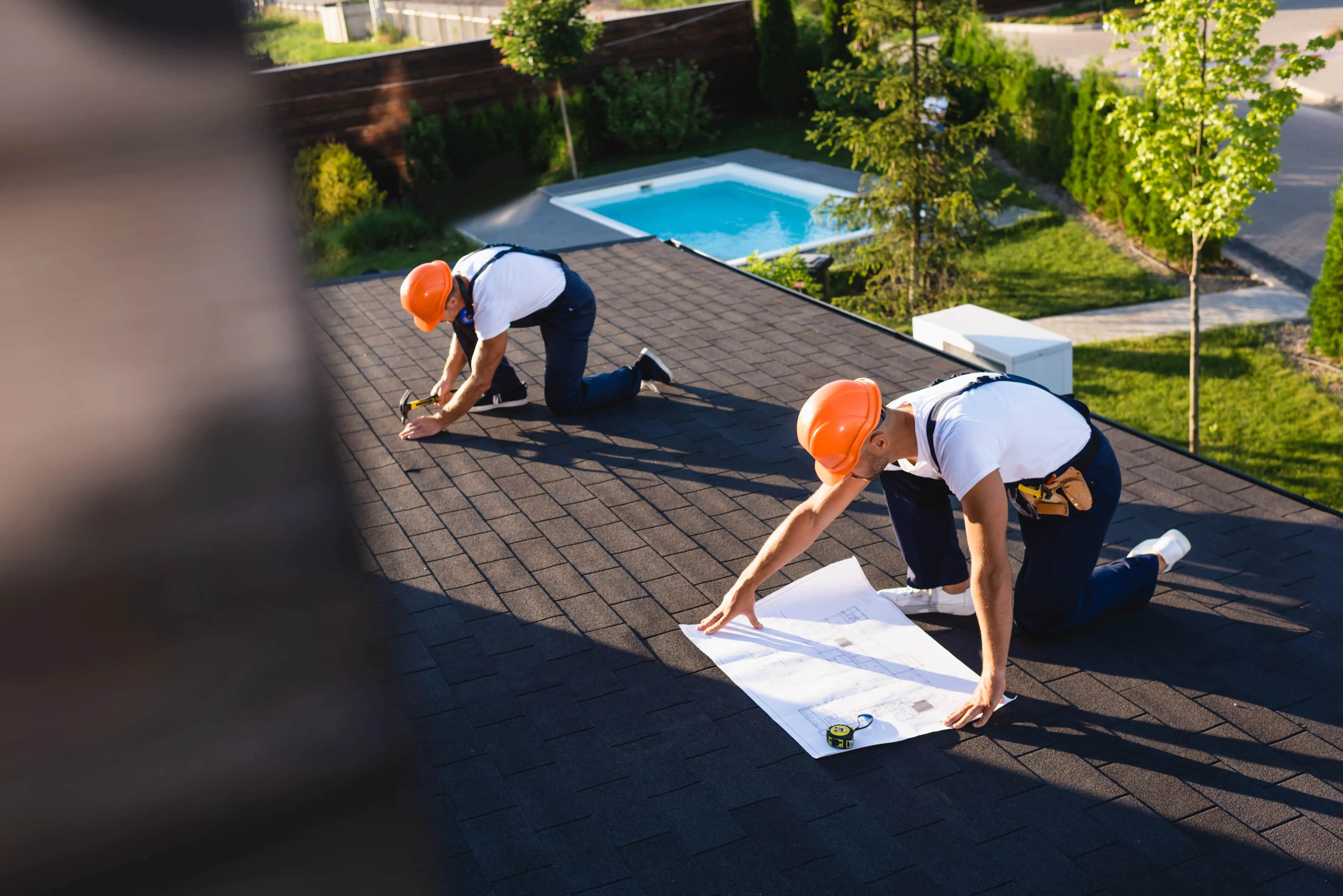 Two roofers working on a residential roof after winning work through Google Ads